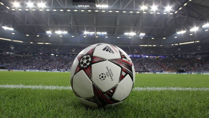 A soccer ball sits on the grass in a stadium with 9 Best Adidas Soccer Balls.