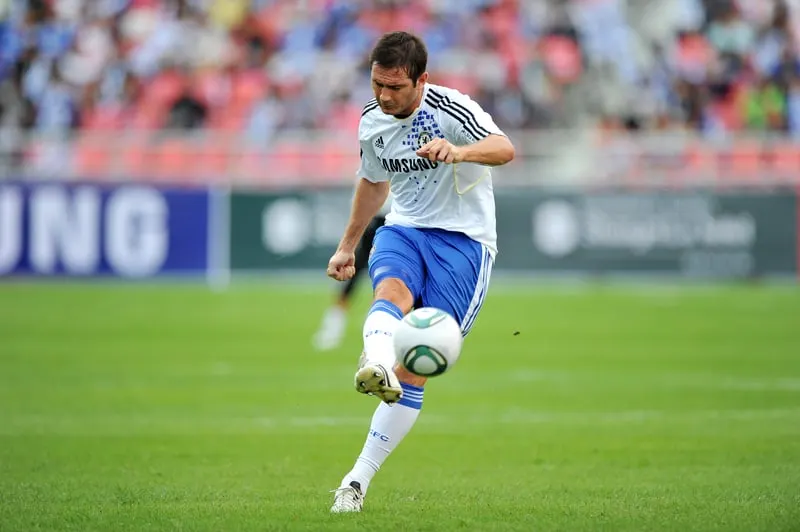 A man skillfully kicking a soccer ball on a field, showcasing his proficiency as one of the 15 Best Penalty Takers of All Time.