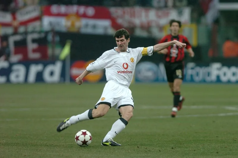 A man, considered one of the 15 best Premier League midfielders of all time, effortlessly kicks a soccer ball.