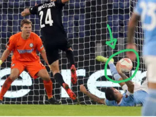 A soccer player is defending a goal.